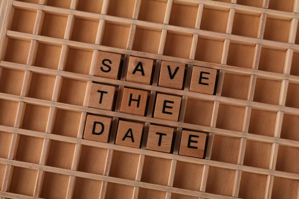 "Save the Date" spelled with wooden tiles for event invitations or reminders.
