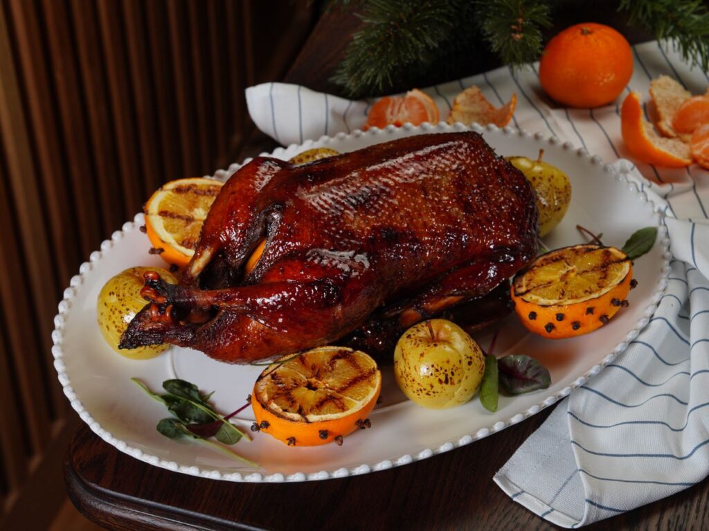 Savor a perfectly roasted duck accompanied by grilled citrus, ideal for festive and elegant meals.
