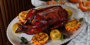 Savor a perfectly roasted duck accompanied by grilled citrus, ideal for festive and elegant meals.