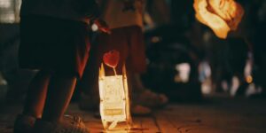 Children holding lit lanterns during a night festival, creating a warm and festive atmosphere.